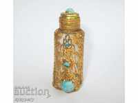 Old antique perfume bottle with gilded ornaments