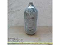 OLD SODA SIPHON, GLASS BOTTLE SOLIDLY COATED IN NET